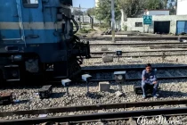 A man sat alongside the rail track.