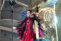 Girl dressed in a red costume standing on top of a Carnival float in Aguilas