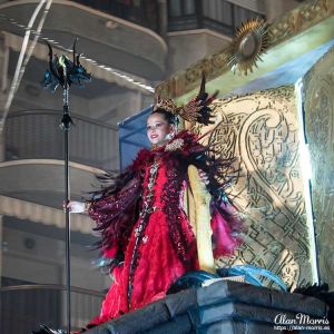 Girl dressed in a red costume standing on top of a Carnival float in Aguilas