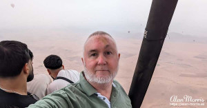 Alan Morris in the basket of an air balloon over the desert. Alan Morris in the basket of an air balloon over the desert.