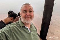 Alan Morris in the basket of an air balloon as it rises off the ground.