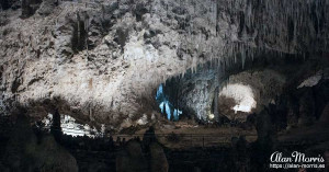 A lit path winds through a large cave in Carlsbad Caverns. A lit path winds through a large cave in Carlsbad Caverns.