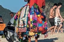 Man selling towels, blankets & bags on Copacabana Beach.