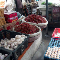 Garlic, peppers & eggs for sale on a stall in the food market. Garlic, peppers & eggs for sale on a stall in the food market.
