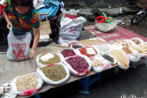 Maggots & grubs for sale alongside noodles on a stall in a Chinese food market.