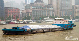 Covered cargo container ship on the Huangpu River in Shanghai. Covered cargo container ship on the Huangpu River in Shanghai.
