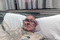 Alan Morris on his bed in a small room in Hostal Viky