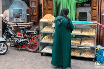 Lady buying biscuits or bread at a shop.