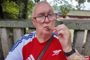 Alan Morris eating grilled oysters at Miyajima Island.