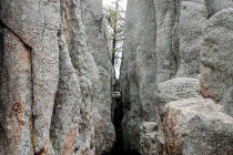 People walking through the tunnel through the Needles Eye rock formation.