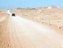 Car driving along dirt road at the Pachacamac complex.