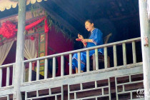 The mother of the bride looks out over the gathered crowd below her.