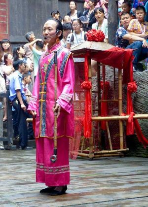 Matchmaker talks to the seated crowd at the Tribe of the 3 Gorges.