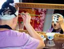 Performer in the Sichuan Opera & Folk Art show putting his make-up on.