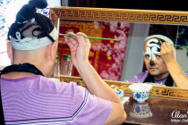 Performer in the Sichuan Opera & Folk Art show putting his make-up on.