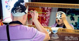 Performer in the Sichuan Opera & Folk Art show putting his make-up on.