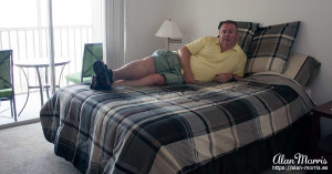 Alan Morris on his bed at his apartment in the Villages of Seaport.