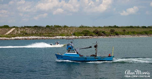 Fishing boat going to Port Canaveral & speed boat leaving Port Canaveral.