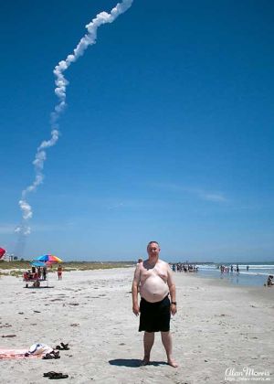 A rocket plume rises into the sky at Cape Canaveral behind Alan Morris.