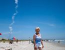 A rocket plume rises into the sky at Cape Canaveral behind Jean Morris.