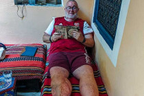 Alan Morris reading his Kindle in the courtyard of Riad El Falili.
