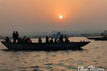 Boat passes by on the River Ganges as the sun rises in Varanasi.