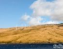 Windmills on Maui, Hawaii as seen from a boat at sea.