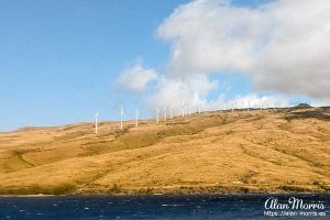 Windmills on Maui, Hawaii as seen from a boat at sea.