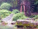 A waterwheel & two boats on the Xiangxi River in the Xiling Gorge.